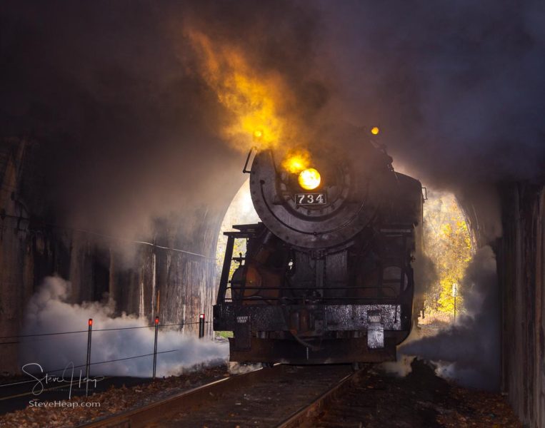 Old 1916 Baldwin steam train on WMRR pulling into a tunnel belching steam and smoke