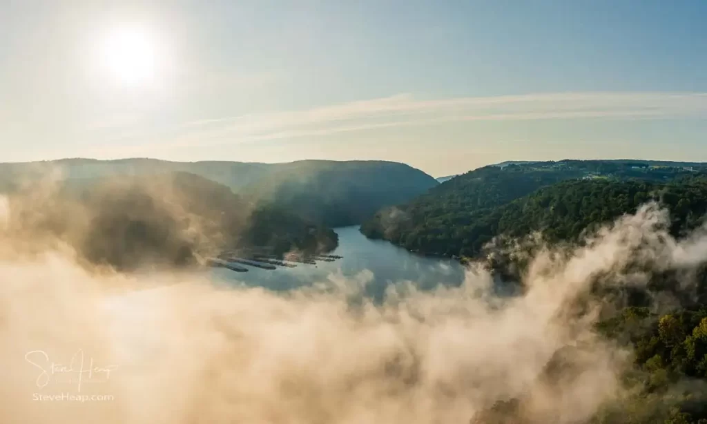 Unusual mist and fog forming over Cheat Lake with aerial view across the lake to marinas and to the Cheat River entering the scene