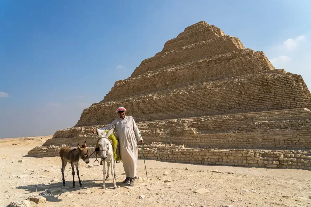 Man with horse and pony posing in front of the Step Pyramid in Egypt