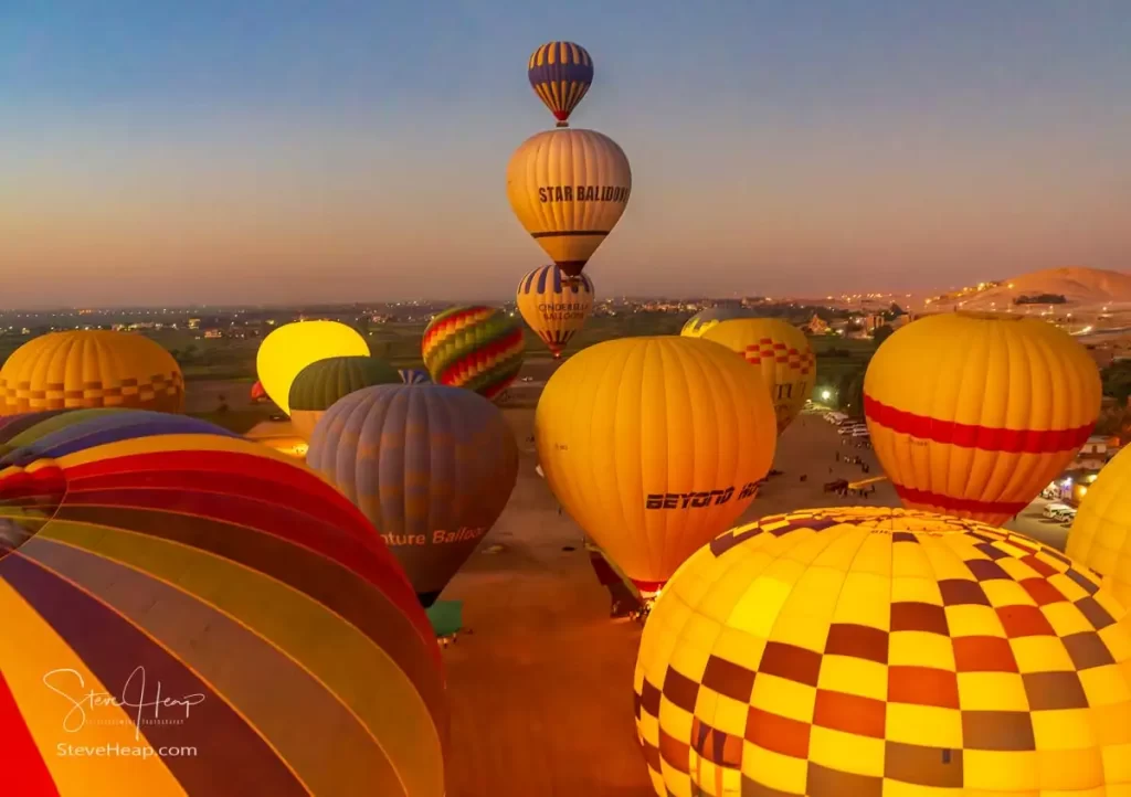 Hot air balloons start to rise from the desert near Luxor in Egypt just before sunrise