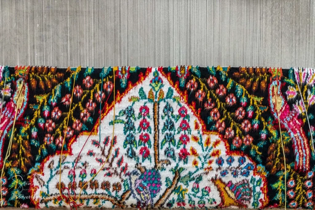 Detail of a partially finished rug or carpet on a loom in the factory