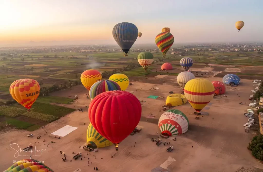 Hot-air balloons rising into the air from the take-off site