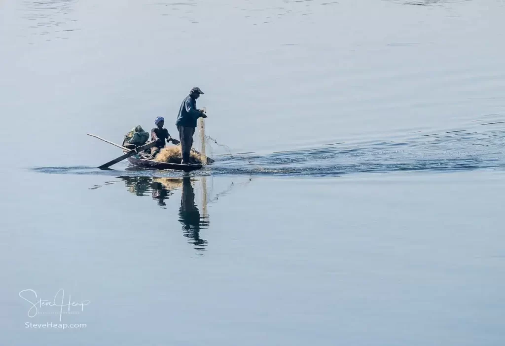 Catching the fish with a long net dragged behind the row boat