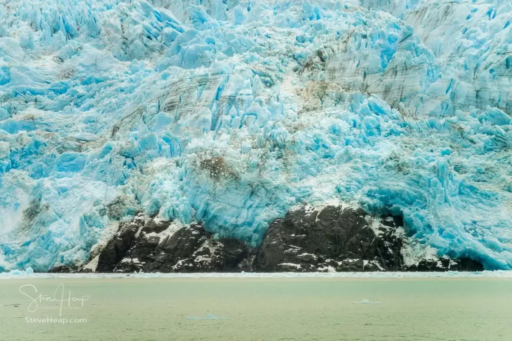 Ice forming the Amalia Glacier piled high behind the rocks at the edge of the fjord. Prints available in my online store